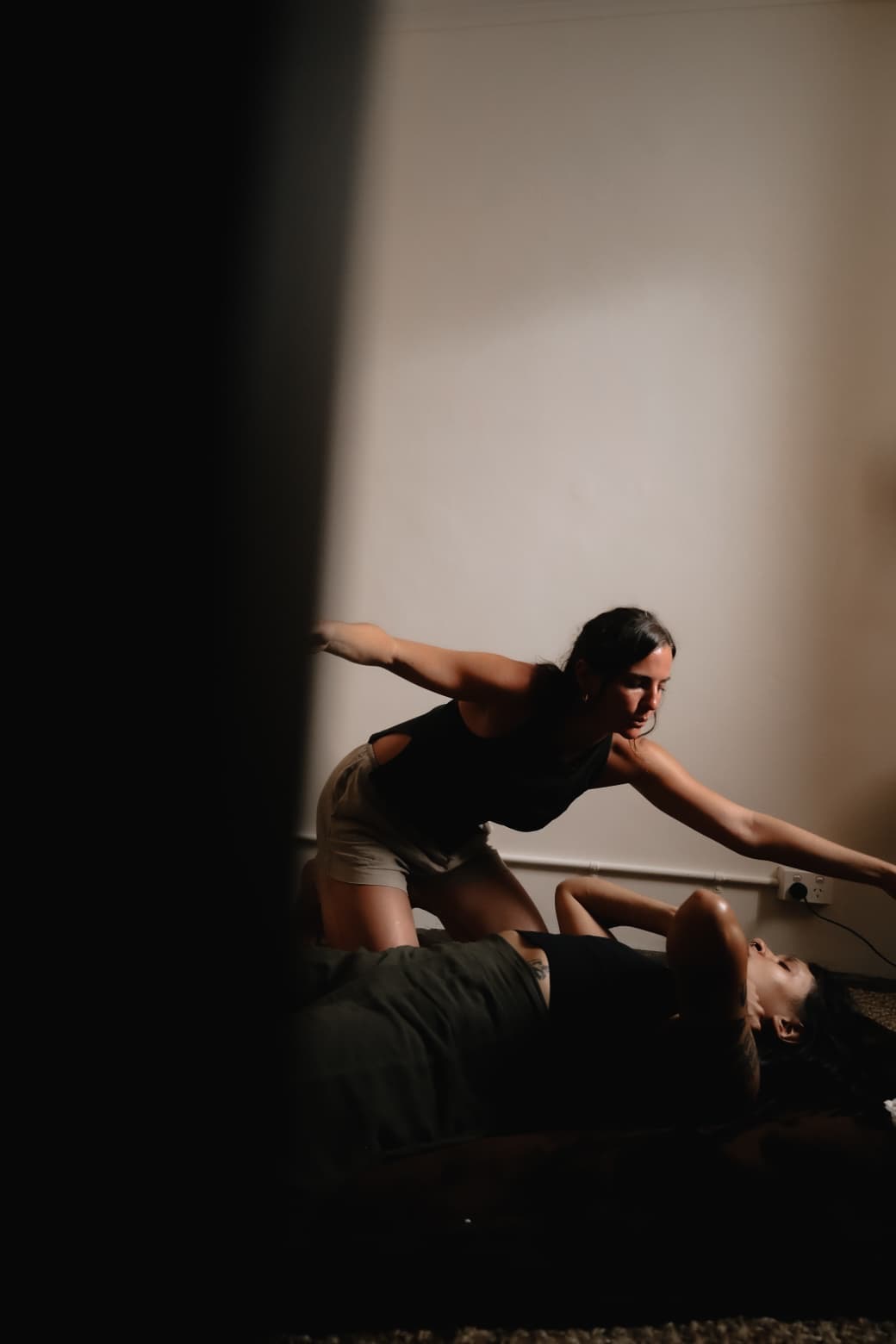 Sarah Elizabeth supporting a client lying on a floor mat during a somatic session